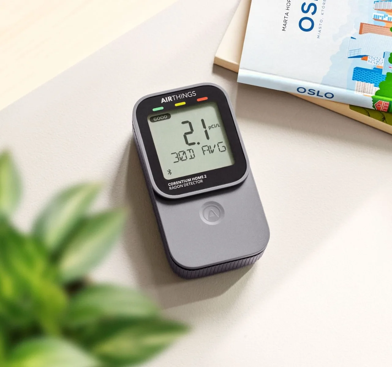 A hand holding an air quality meter in a living room to test the indoor air.